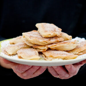 “Rafiolia”: sweet fried cheese pies with mizithra and honey or sugar and cinnamon, in the shape of a crescent, a traditional carnival treat.